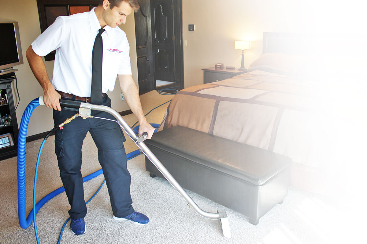 Carpet cleaning technician cleaning carpet in a bedroom